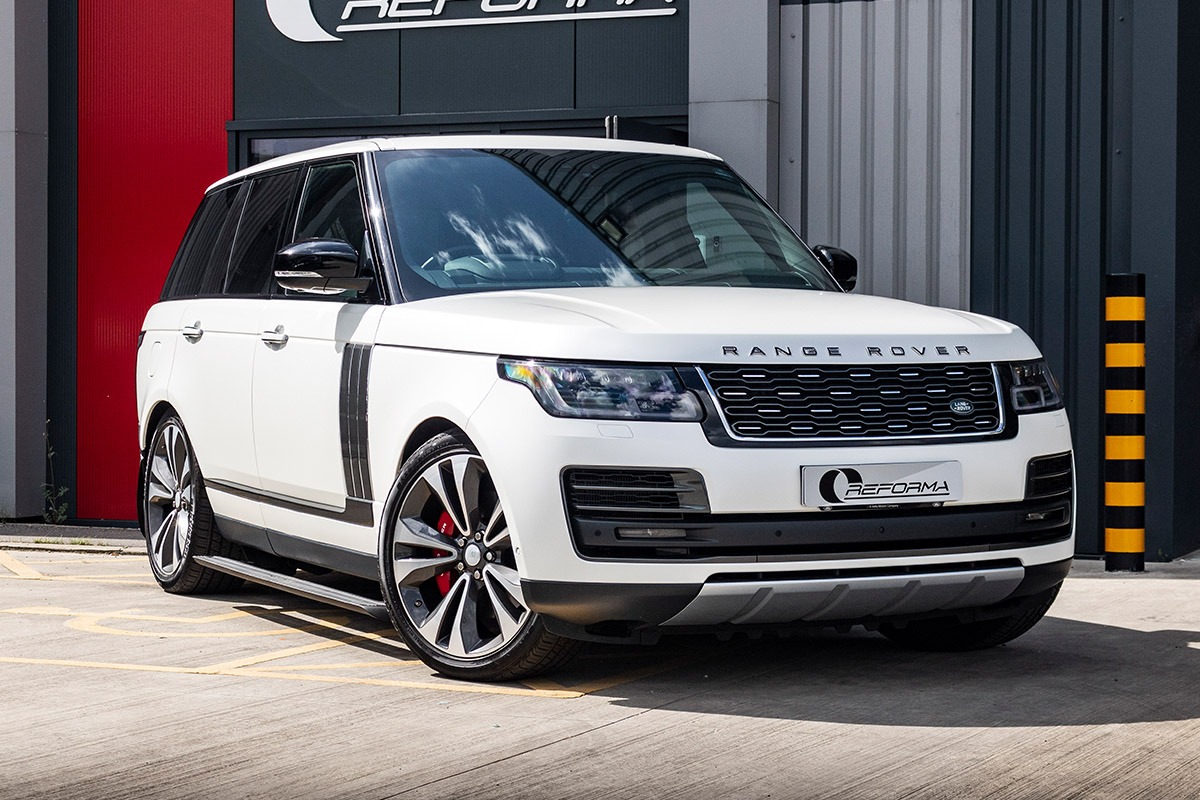 Range Rover — Vogue in pearl-white full wrap, wrap-shop setting.
